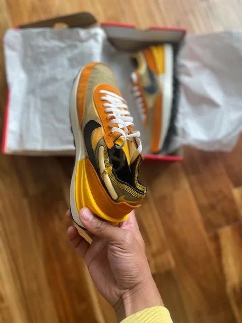 writer holding a nike waffle one sneaker