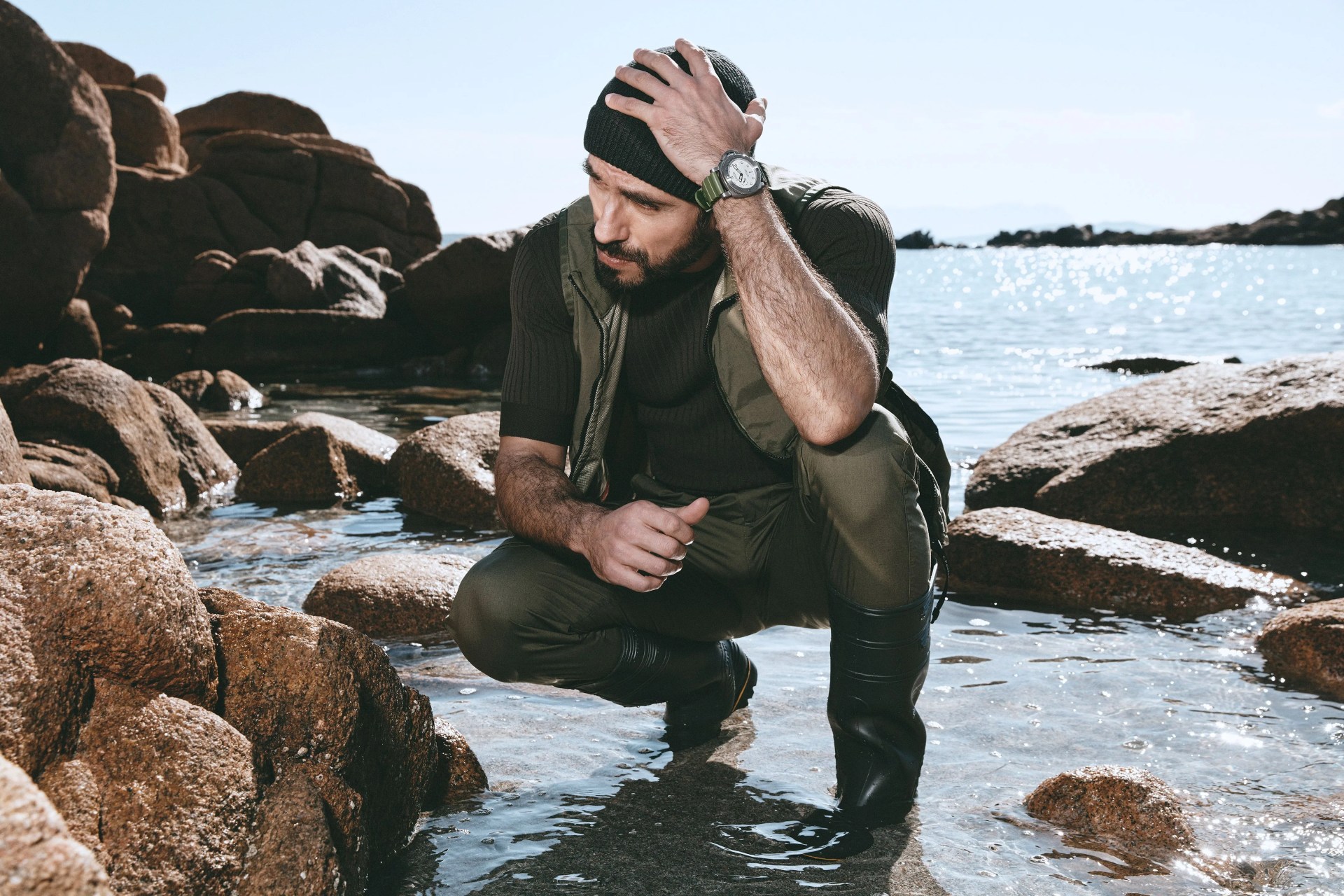 man crouching down in water wearing panerai watch