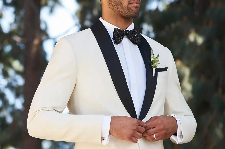 man buttoning his white tux