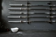 sports chalk bowl under a collection of barbells on a rack
