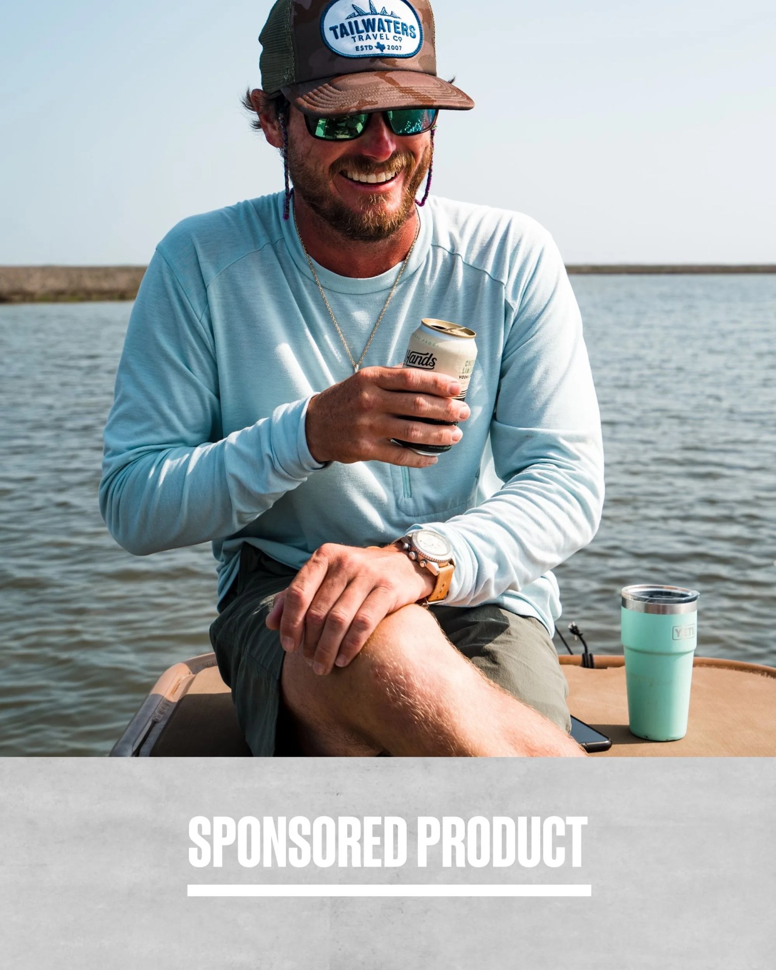 sponsored product man holding all hands craft cocktails vodka soda while sitting in boat