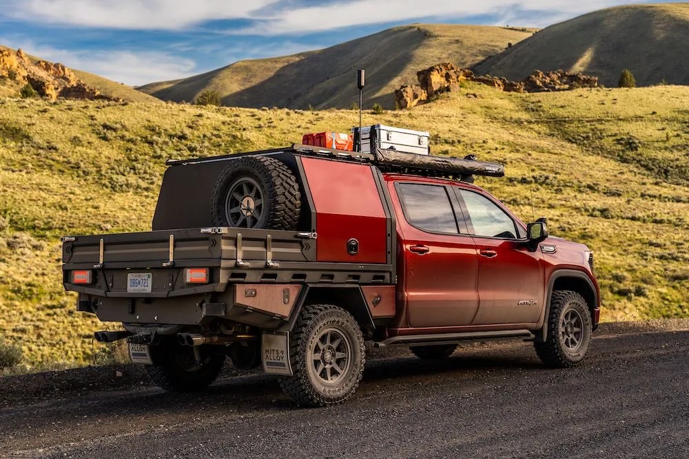 modified gmc sierra 1500 at4x parked on a dirt road with grass covered hills in the background