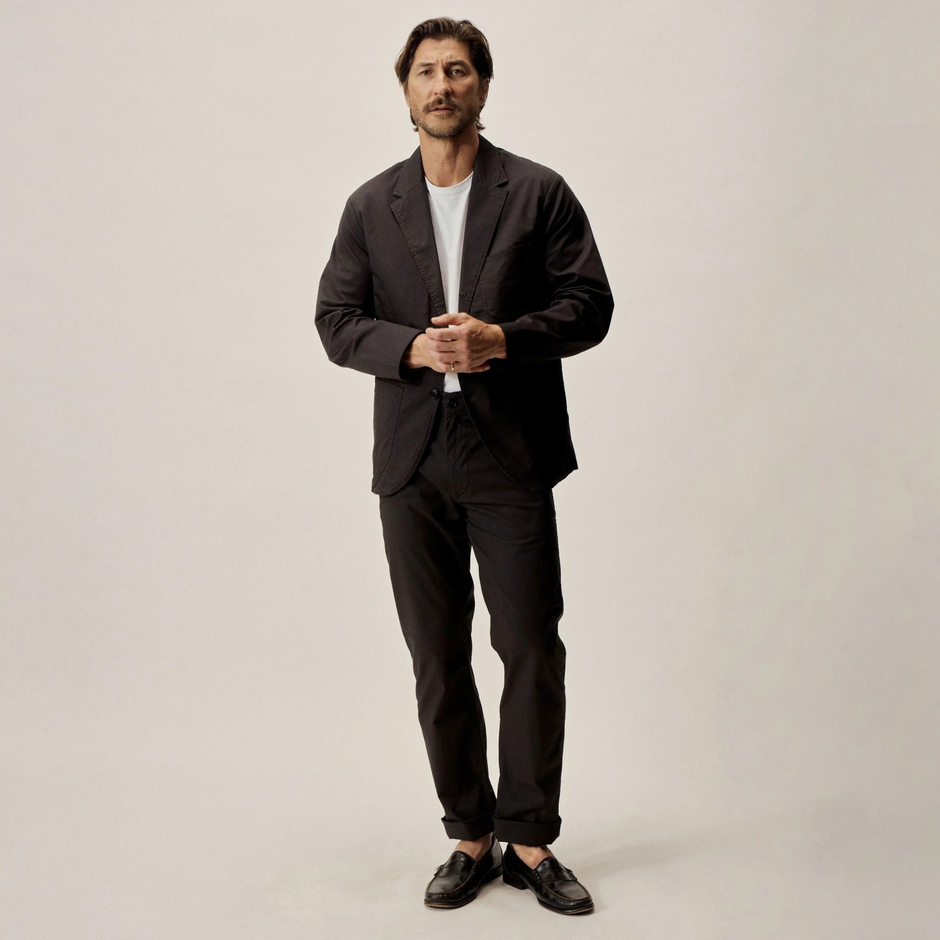 man wearing a black buck mason carry on suit