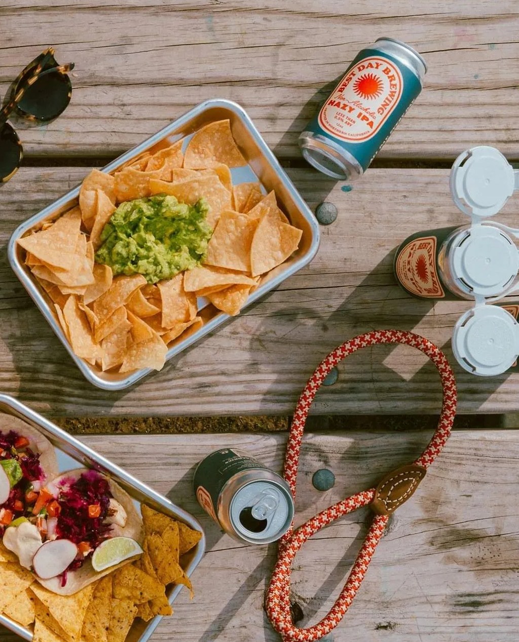 best day brewing craft non alcoholic beer laying on tabel next to people eating nachos and playing cards