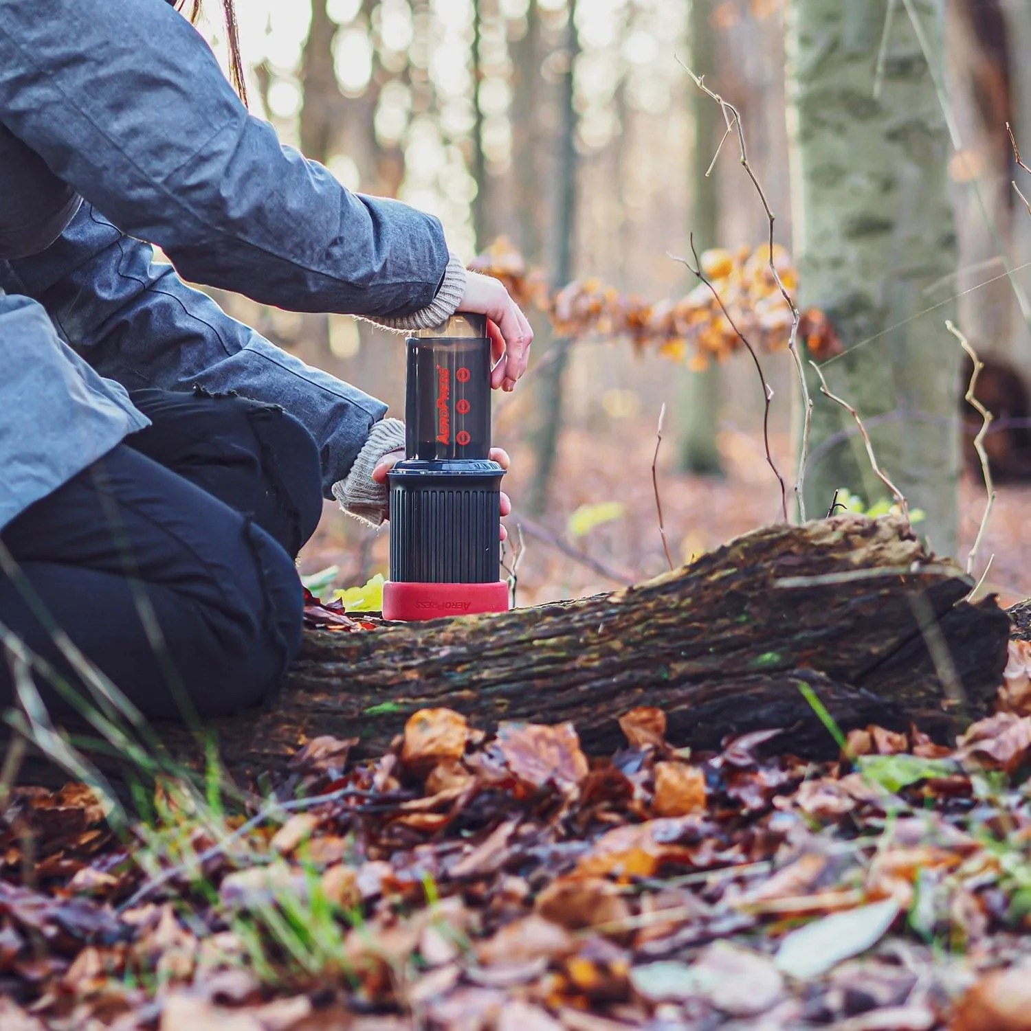 person making coffee with the aeropress go portable travel coffee press in the woods
