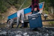 man carrying yeti roadie 24 18 can hard cooler to boat docked
