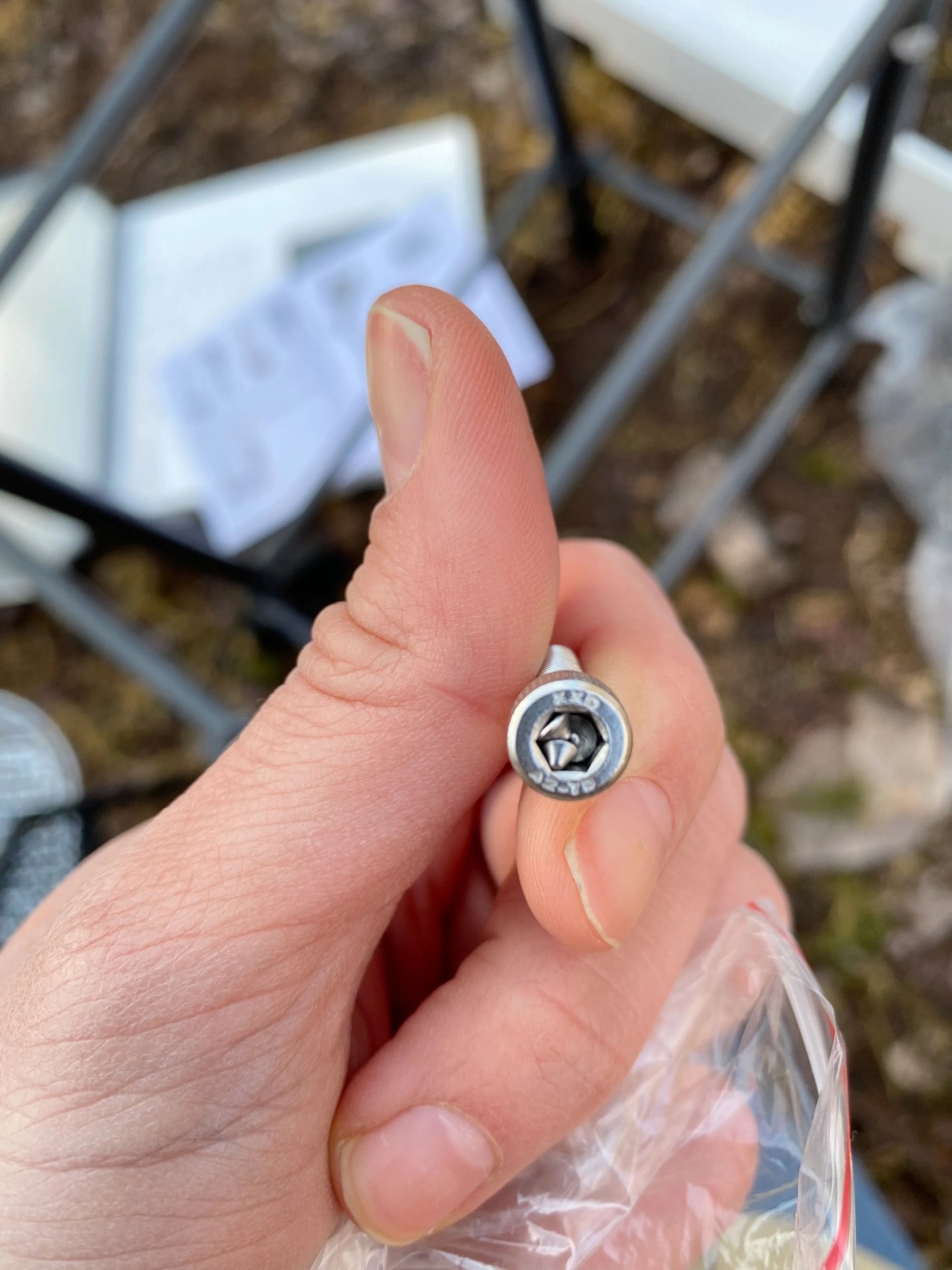 an incomplete screw with metal pieces inside of the drill hole