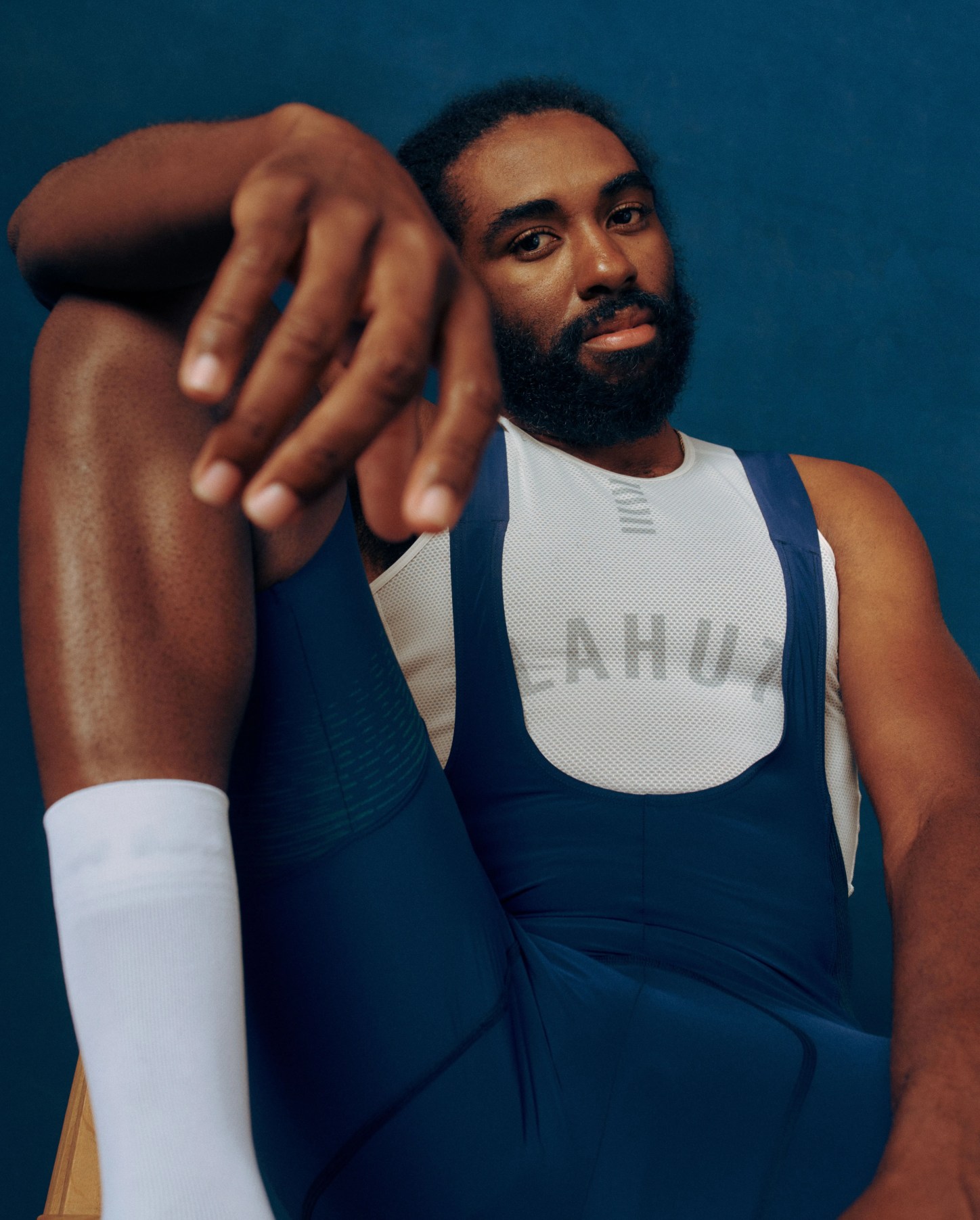 man sitting with one arm propped on leg wearing rapha's powerweave shorts