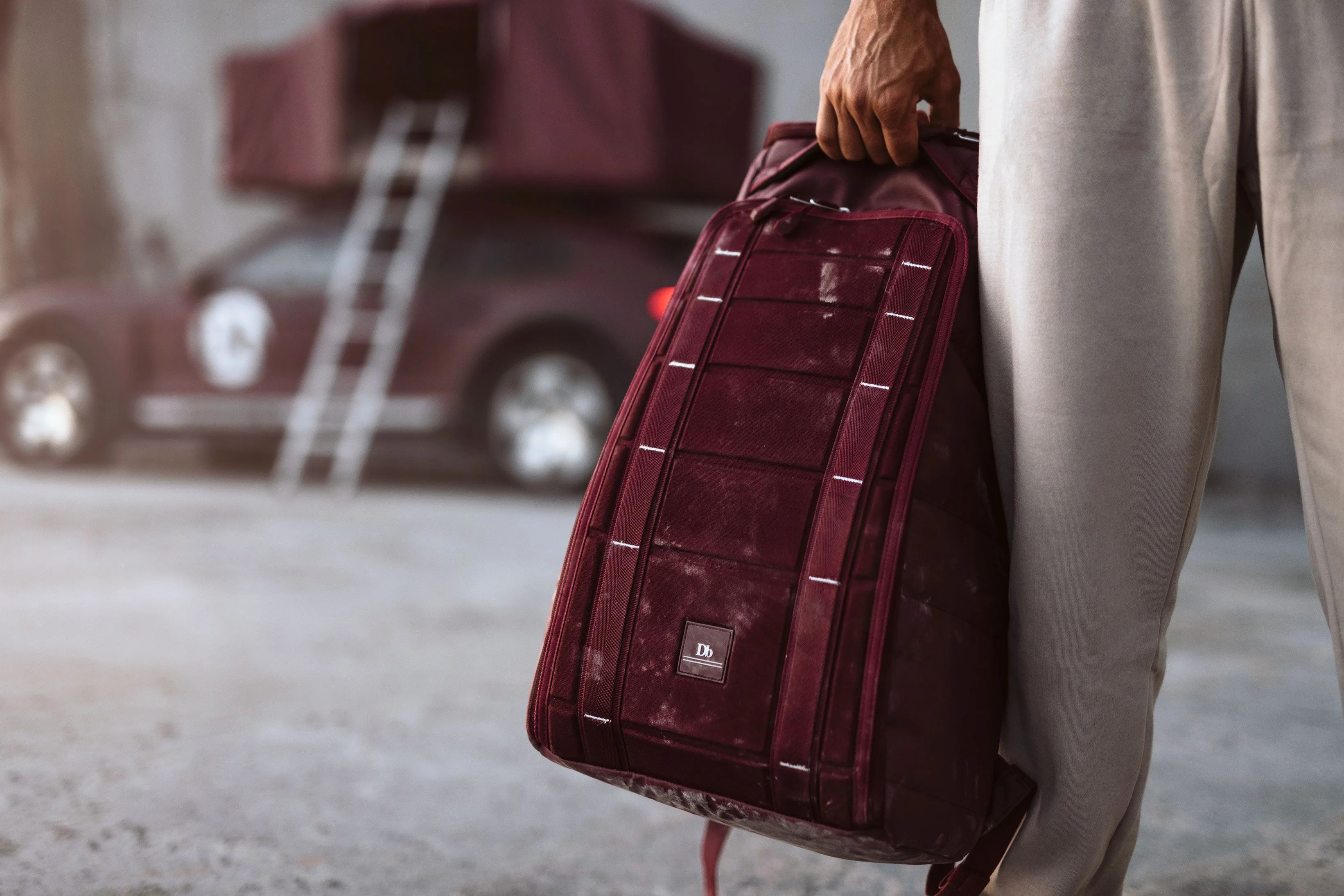man holding magenta db bag