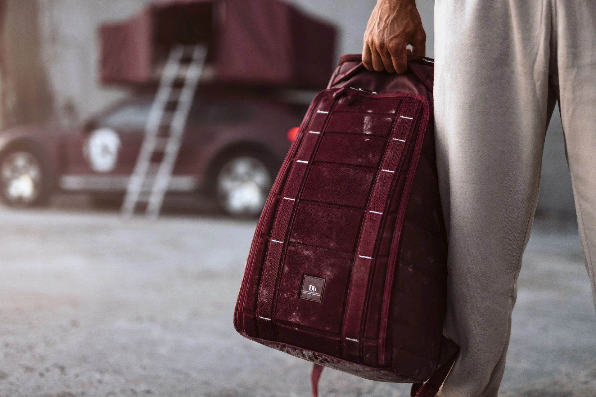 man holding magenta db bag