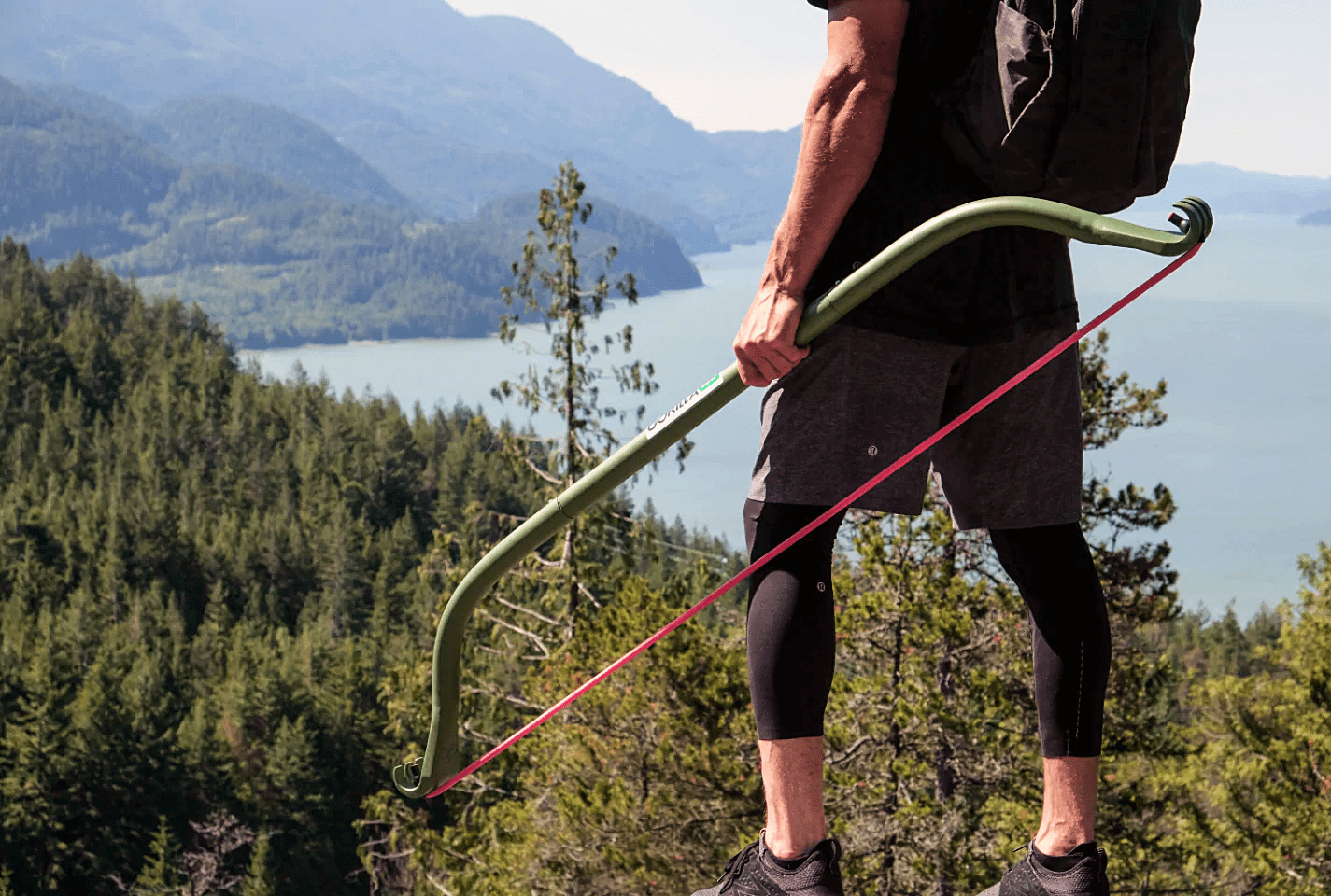 man holding a gorilla bow with a mountain view