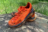 orange hoka one tecton x running shoes sitting on a rock