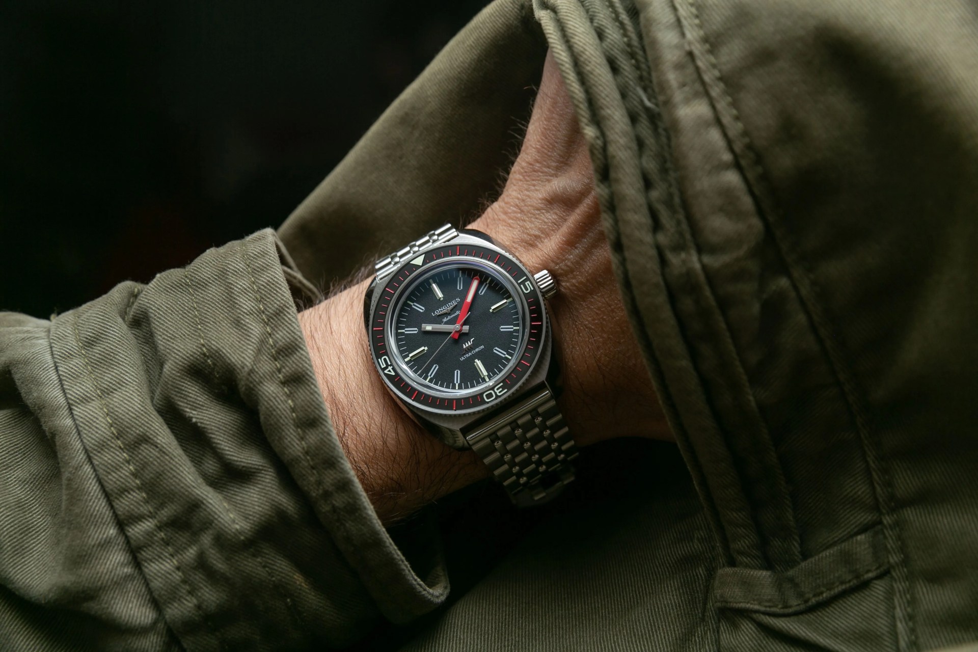 dive watch on wrist with green jacket