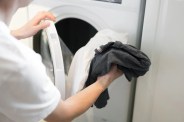 man washing clothes in washing machine