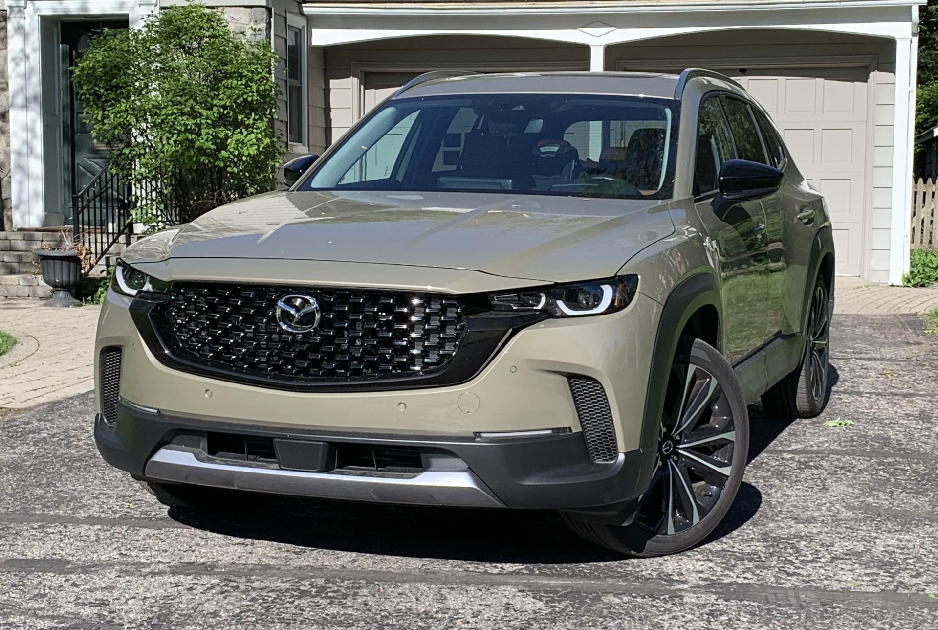 mazda cx 50 parked in a driveway in front of a grey house
