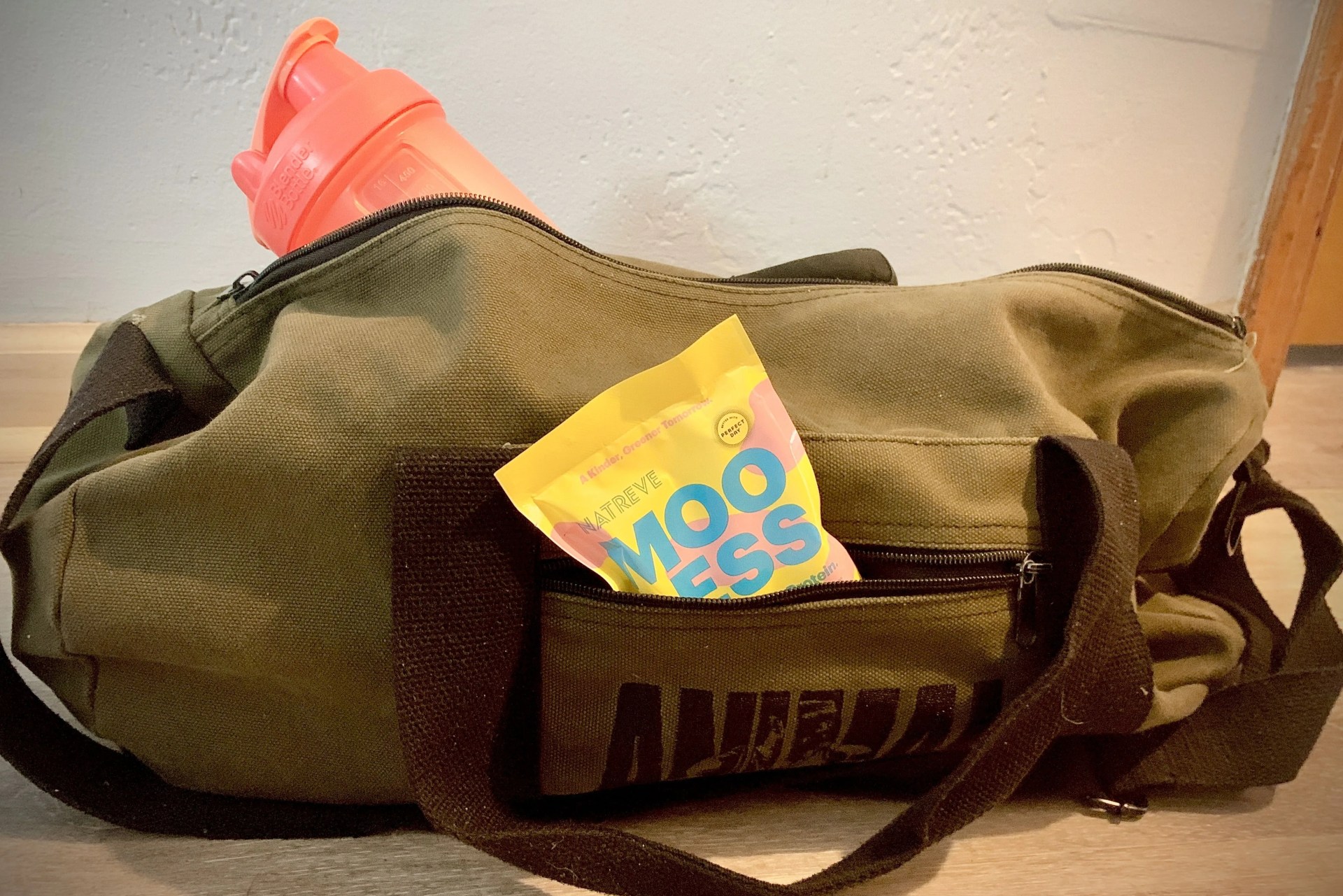 mooless protein packet and shaker bottle in bens gym bag