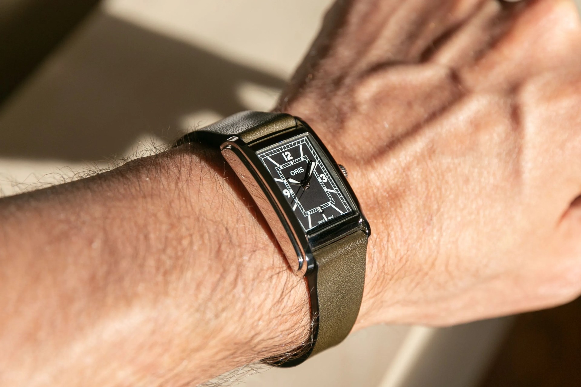 man wearing oris rectangular watch