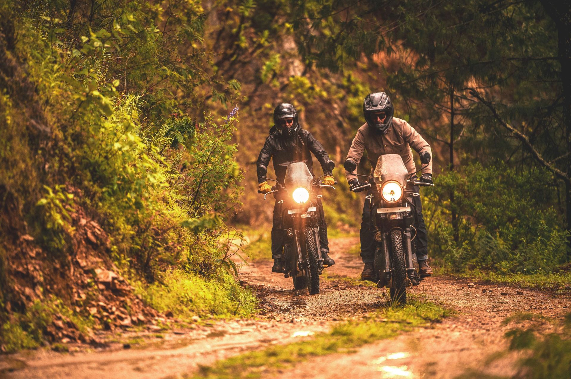 two people riding dirt bikes