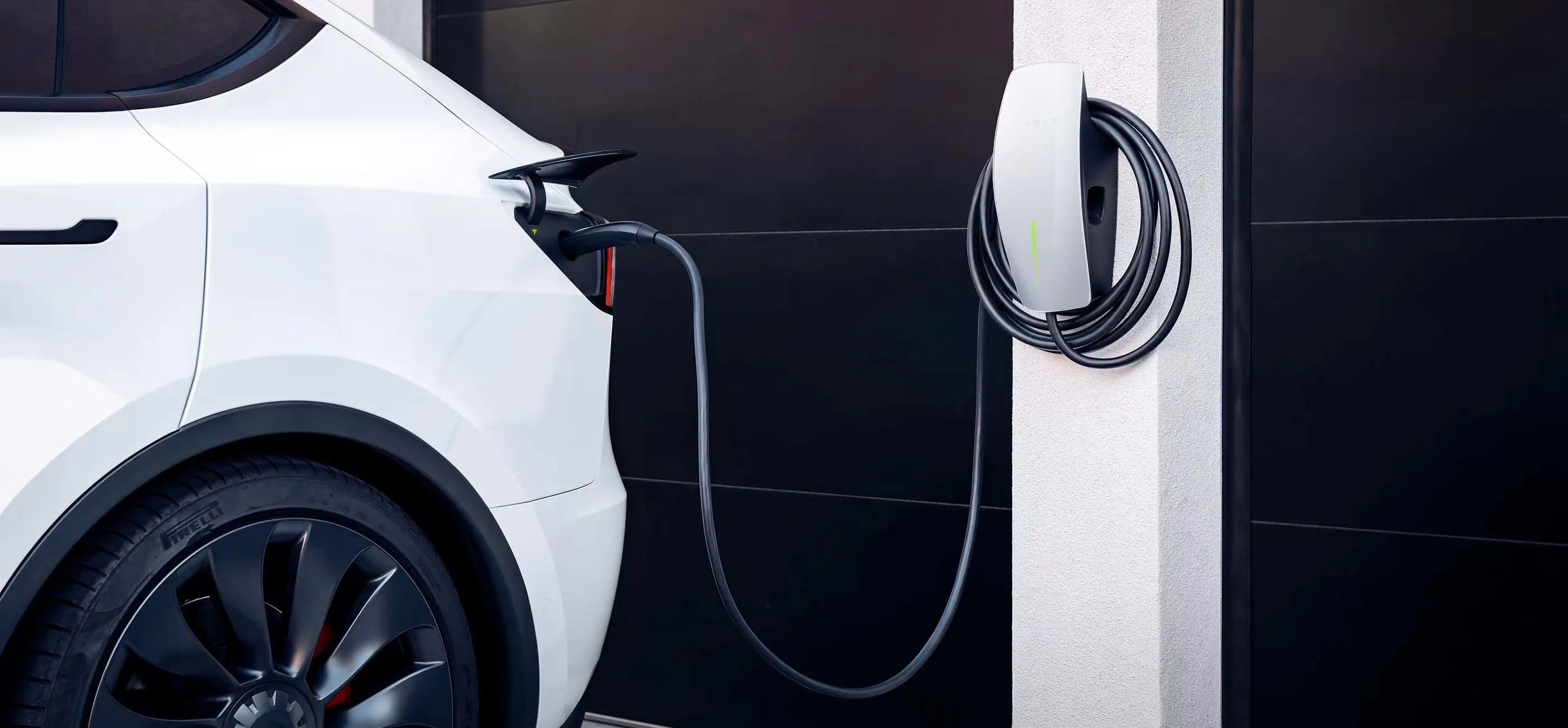 white tesla being charged