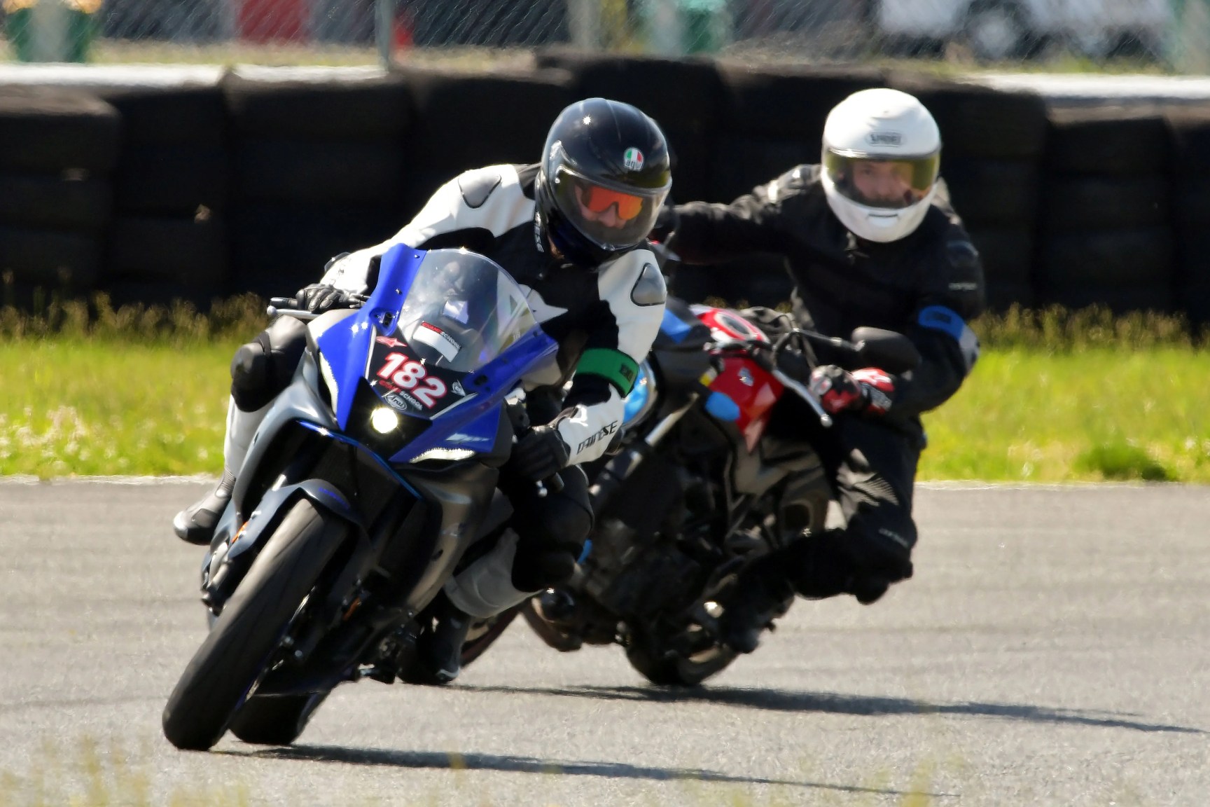 two men riding motorcycles around a track