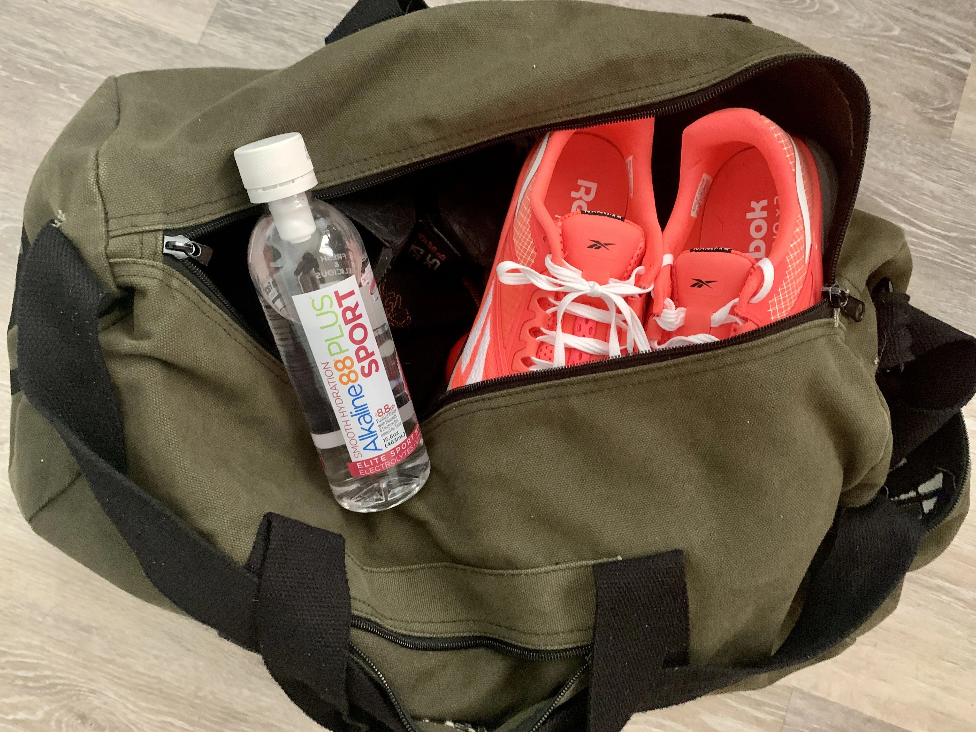alkaline88 sport water on a gym bag with running shoes