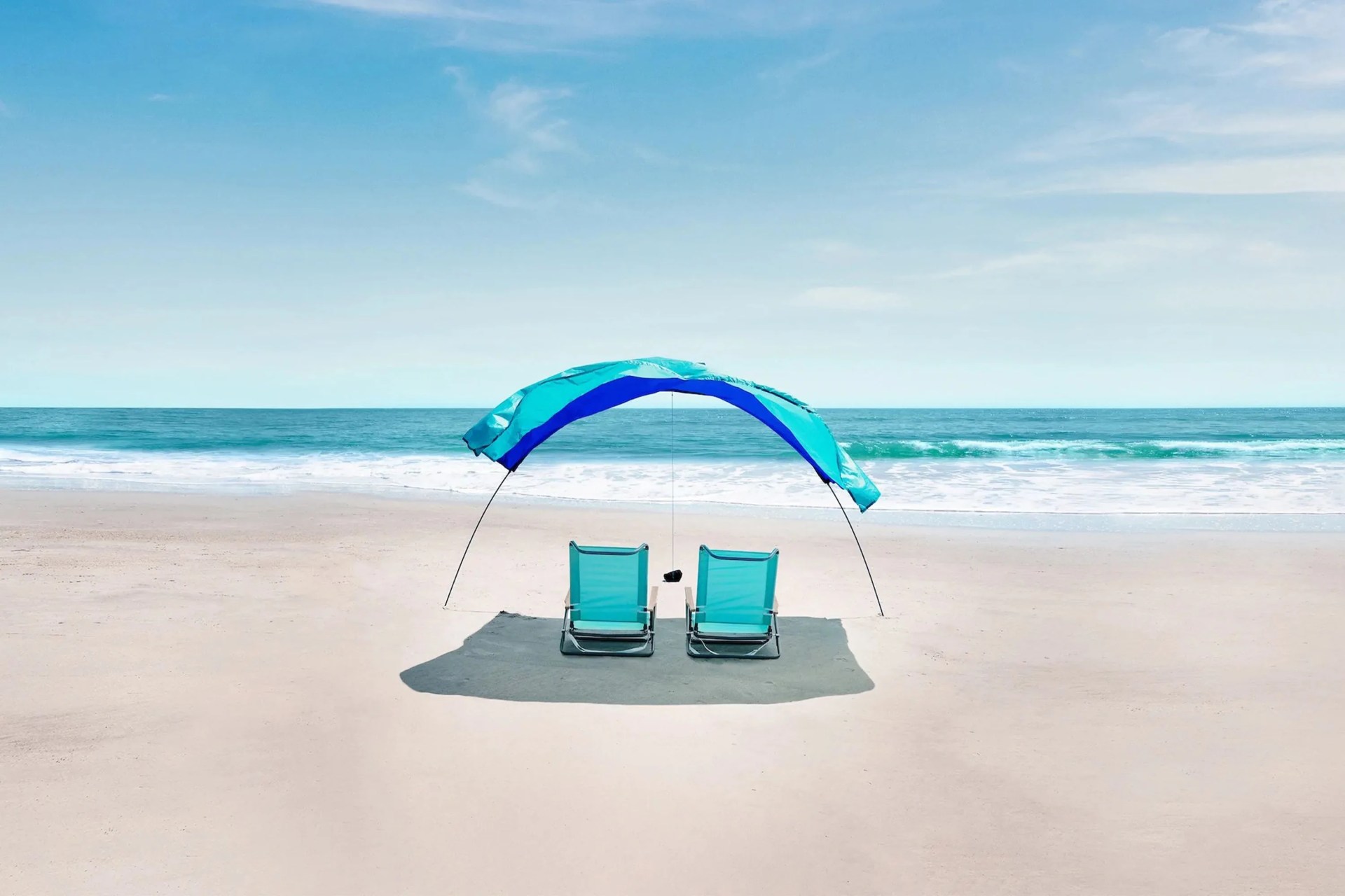 two chairs under a shibumi shade tent on a beach