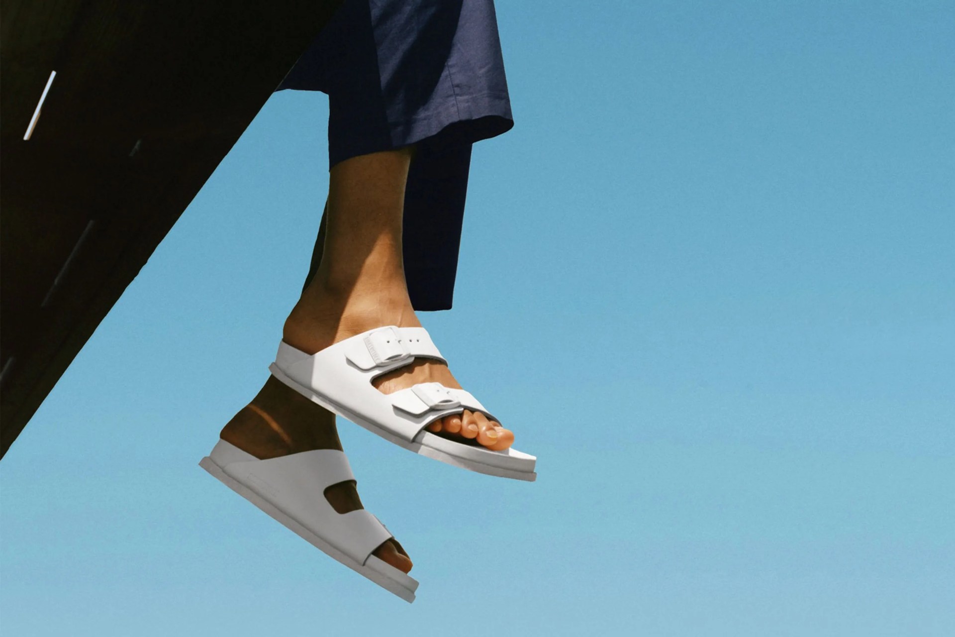 person wearing white birkenstocks