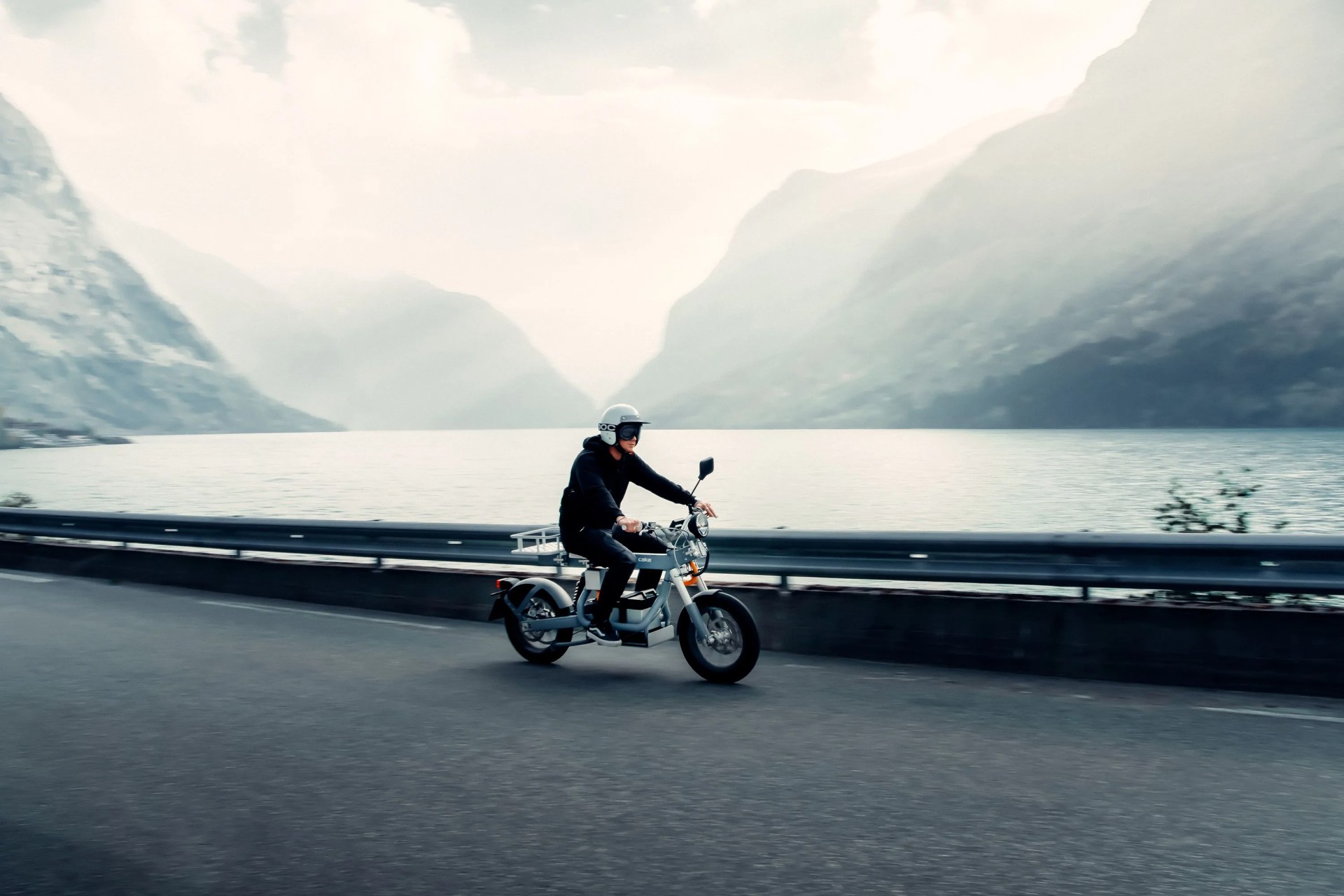 person riding the cake osa motorcycle alongside a lake