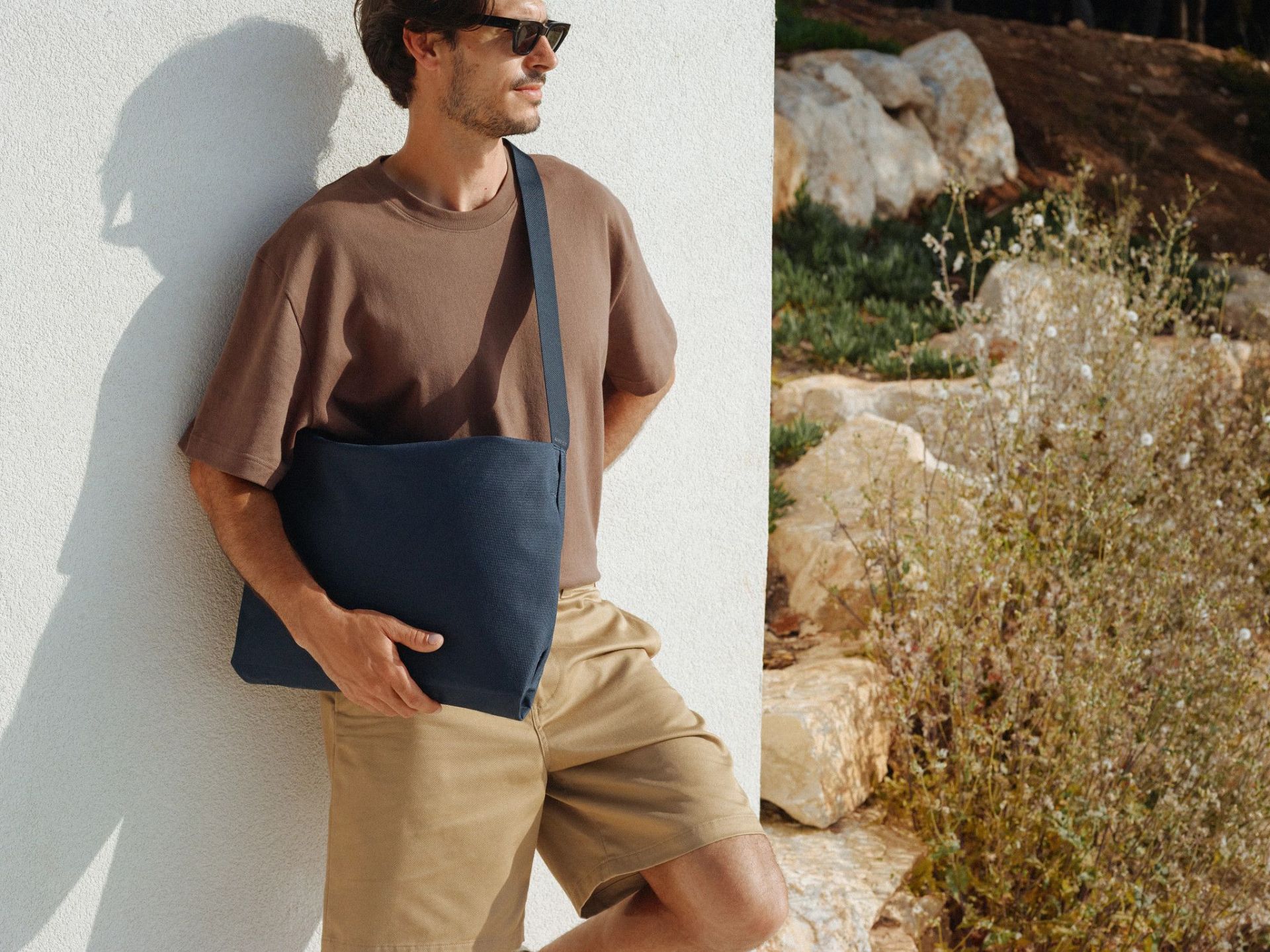 man holding an away messenger bag