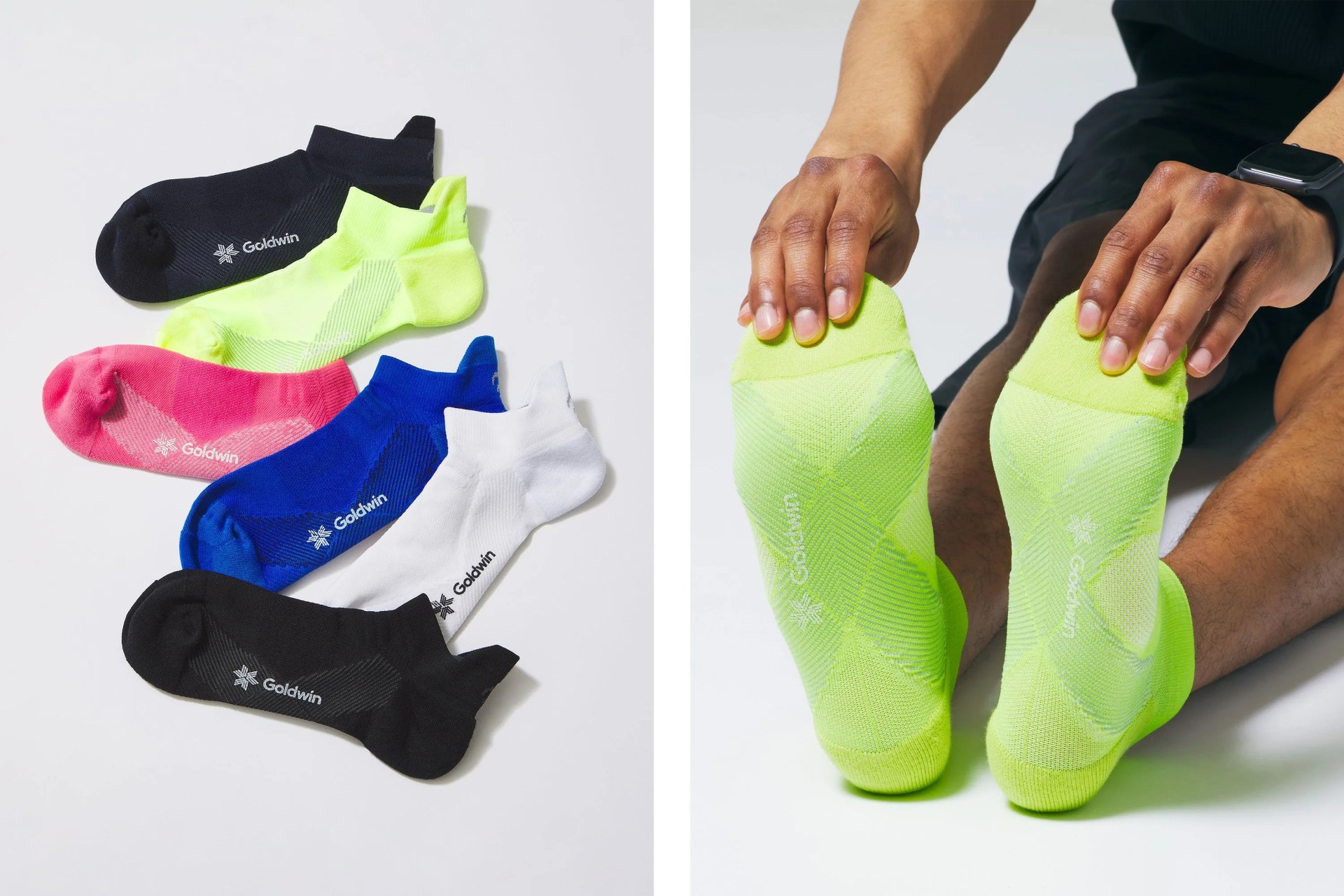 stack of goldwin socks on the left and a man sitting while stretching forward to hold his toes wearing goldwin socks