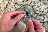 person cleaning silver jewelry with a soft bristle brush