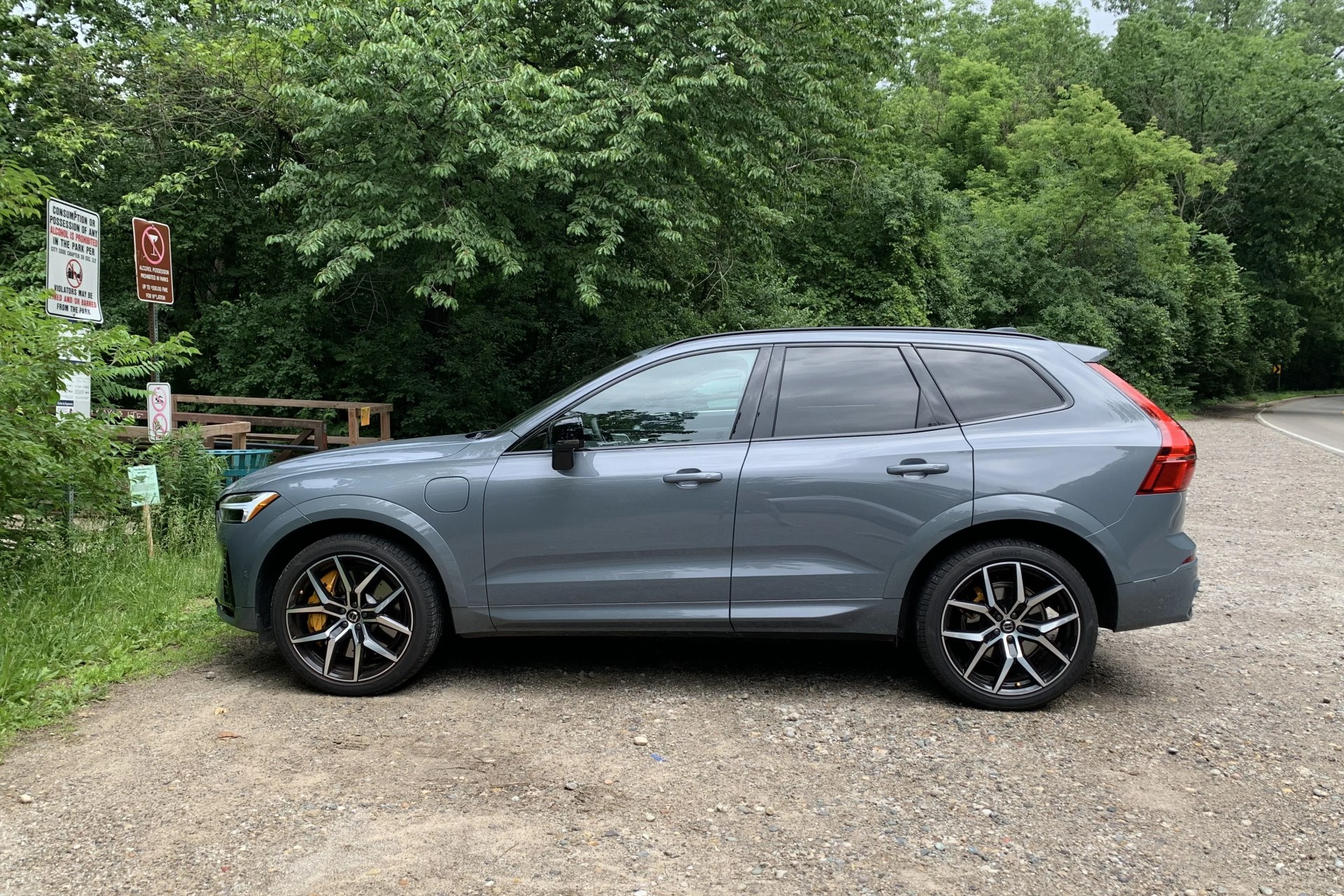 volvo xc60 recharge viewed from the side parked next to woods