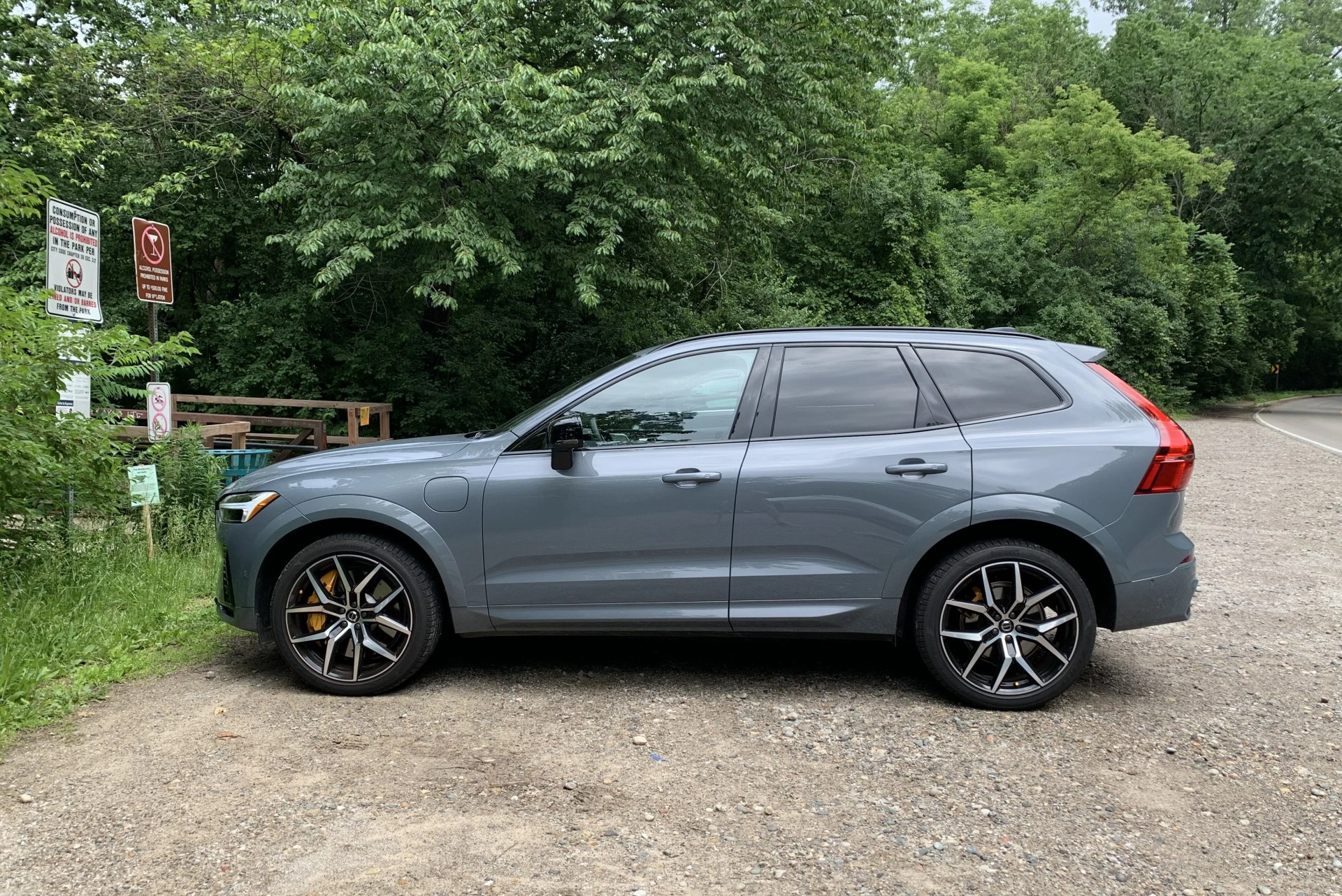 volvo xc60 recharge viewed from the side parked next to woods