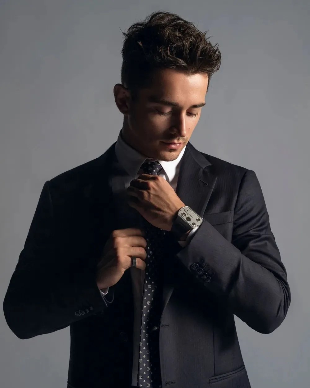 man in a suit adjusting his tie wearing richard mille x ferrari's thinnest watch