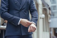 man wearing double breasted suit adjusting his cuff