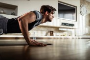 muscular build man exercising push ups at home