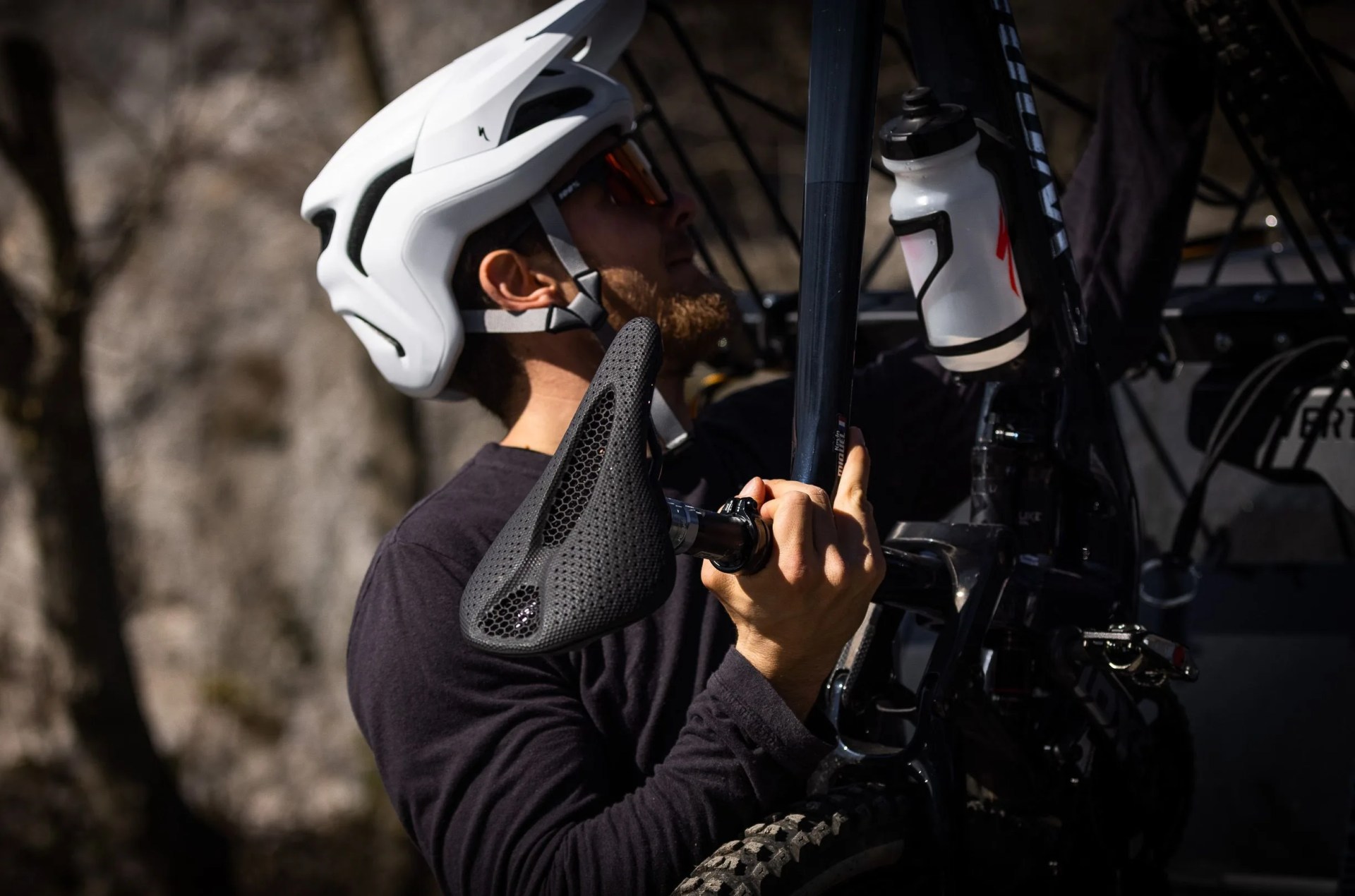 man carrying specialized bike with power pro mirror saddle