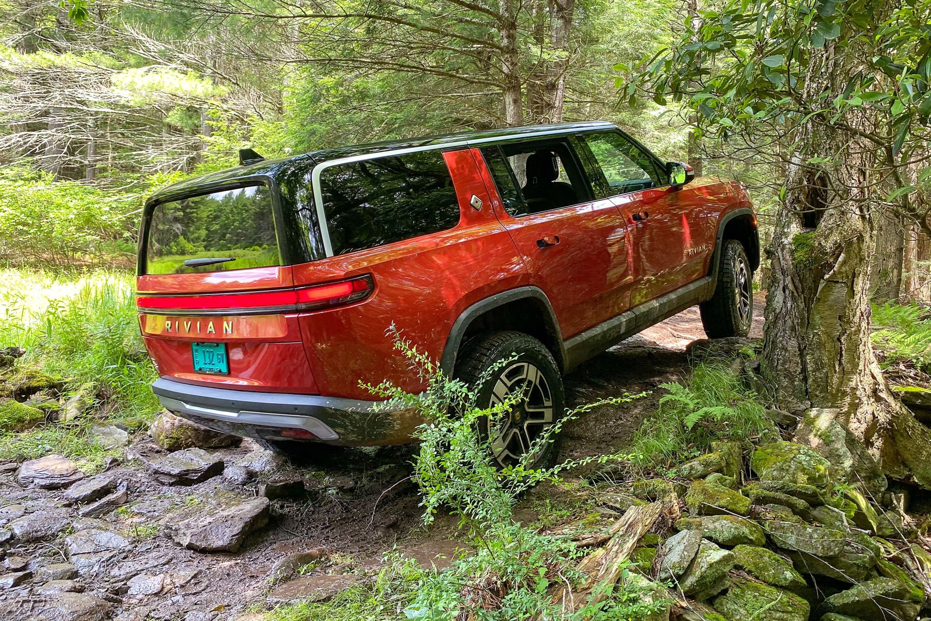 back right side of the rivian r1s driving through the woods