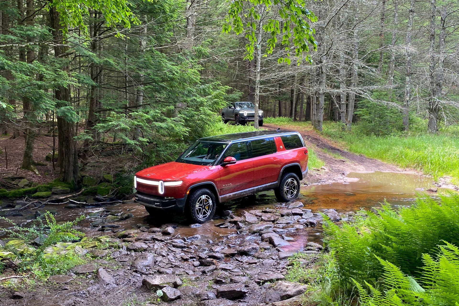 rivian r1s driving through riverbed