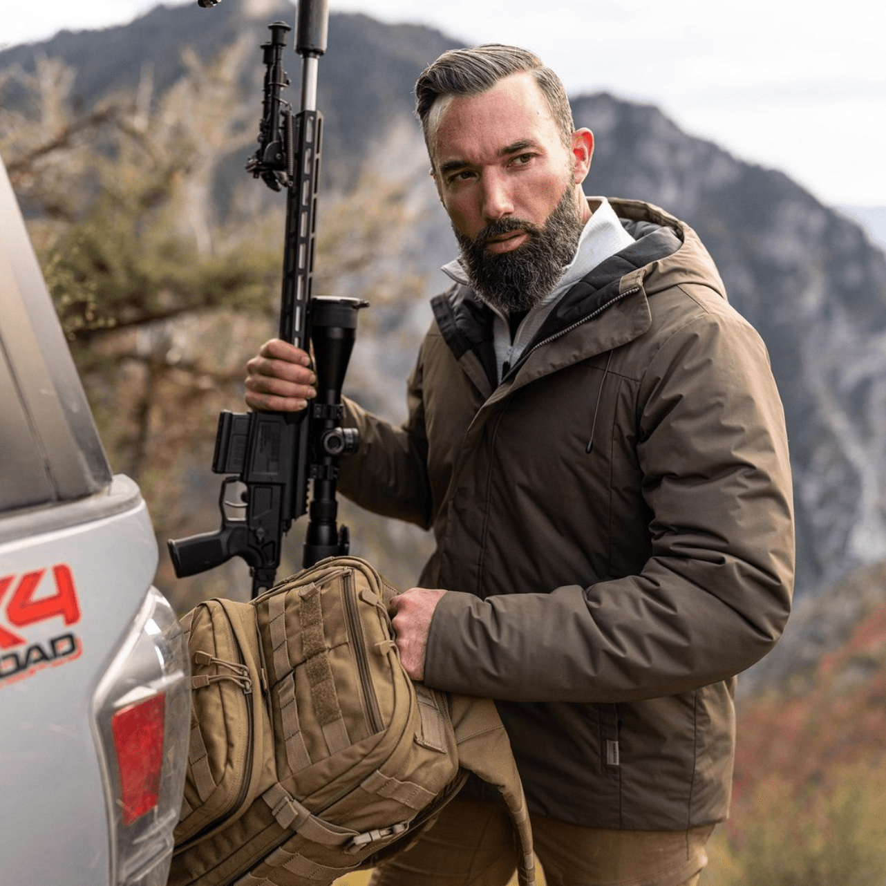 511 tactical clothing ad featuring a man with a military spec backpack and assault rifle he has good hair