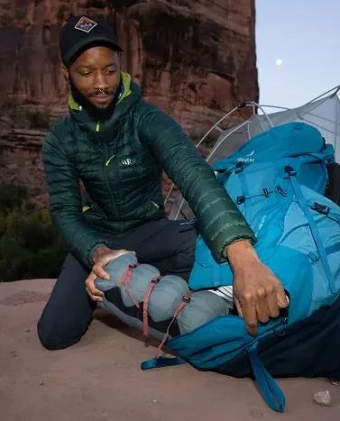 man pulling gear out of deuter backpacking pack