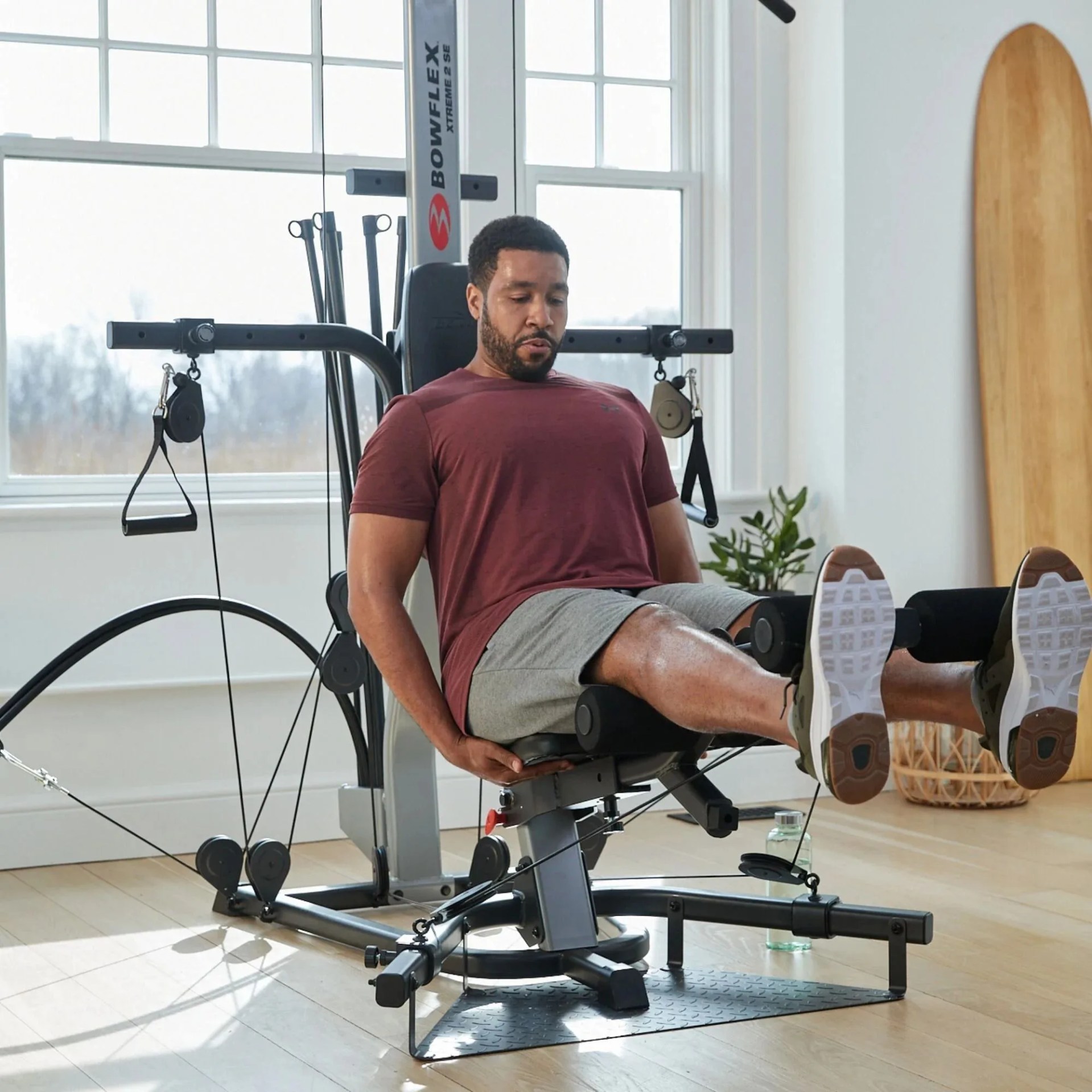 man doing a leg extension on the bowflex xtreme 2 se machine
