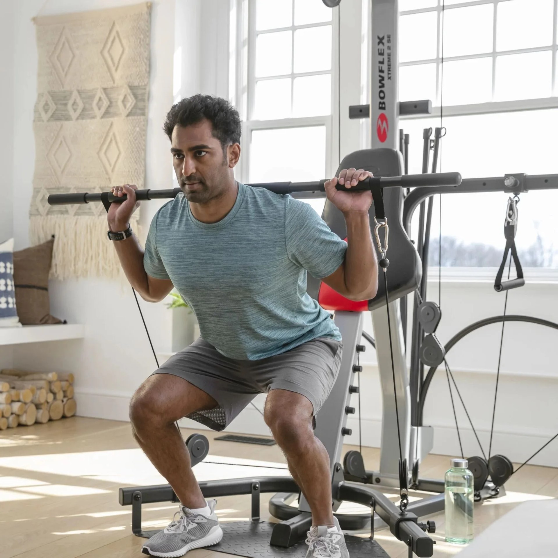 man doing a squat using the bowflex xtreme 2 se machine