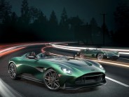 aston martin dbr22 driving next to old open cockpit aston martin race car