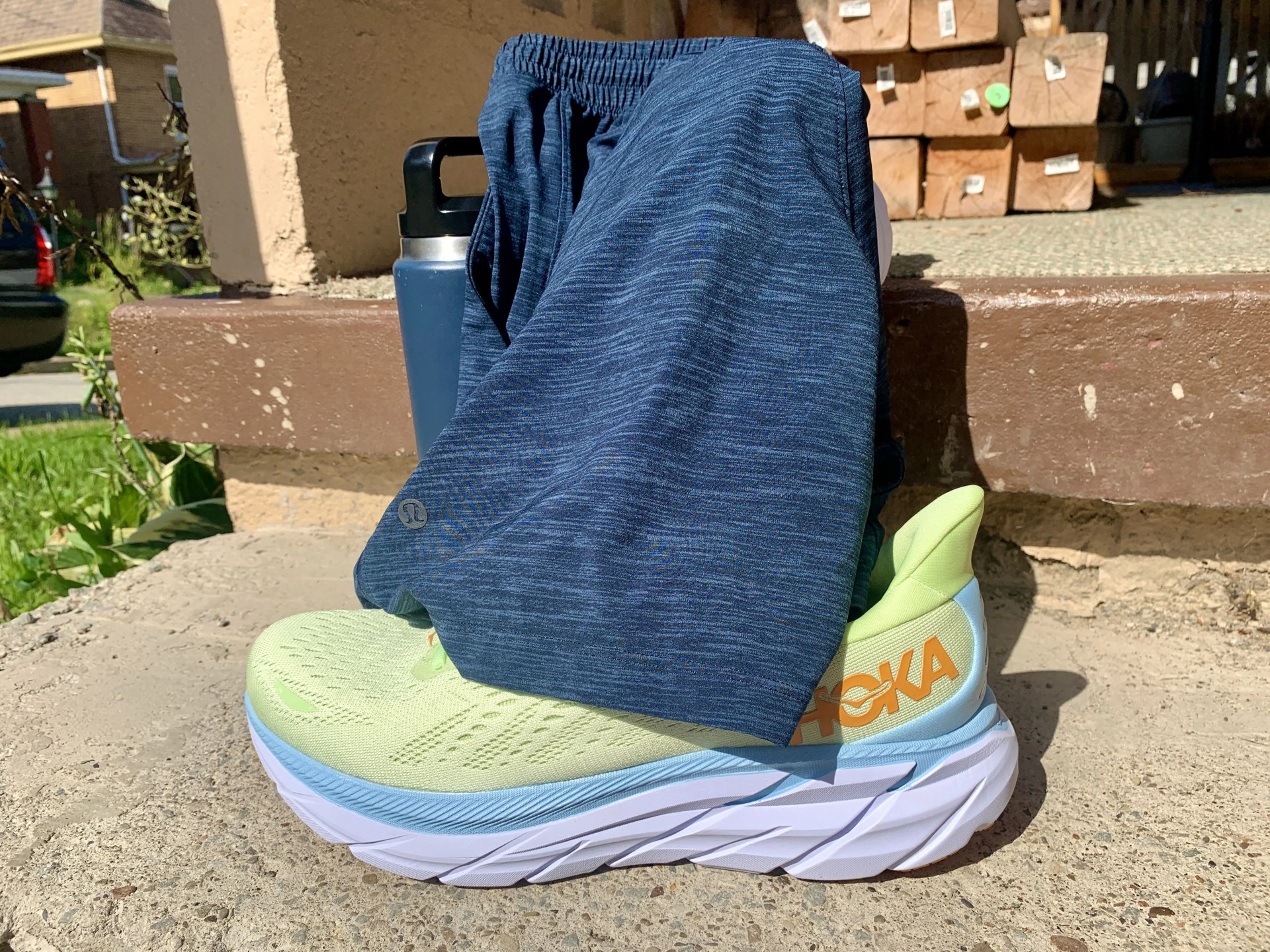 a water bottle and lululemon shorts sitting on hoka shoes