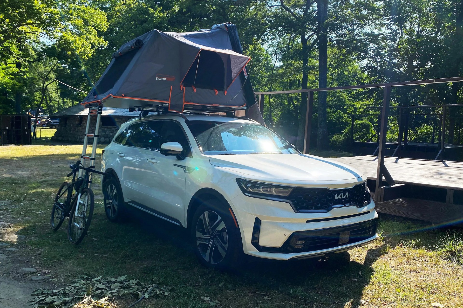 roofnest condor xl tent on top of a white kia with a bike leaning against the ladder