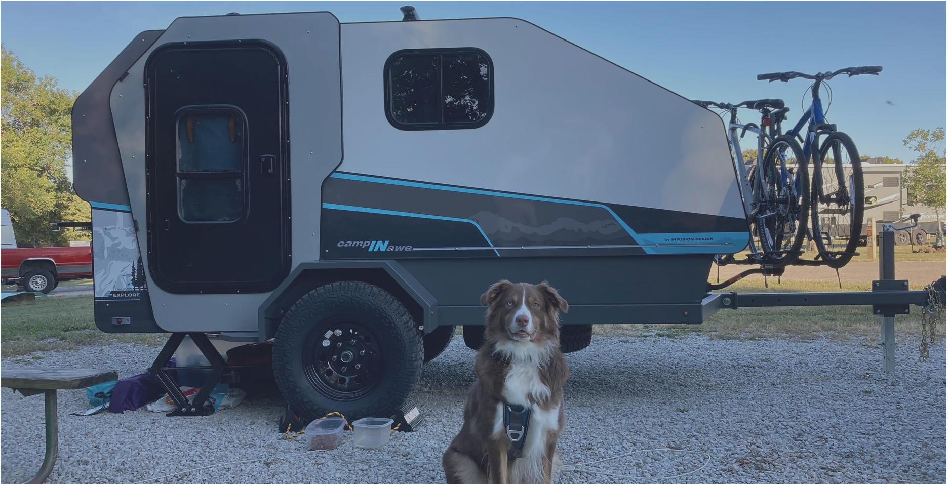 campinawe camping trailer parked at a campsite with dog
