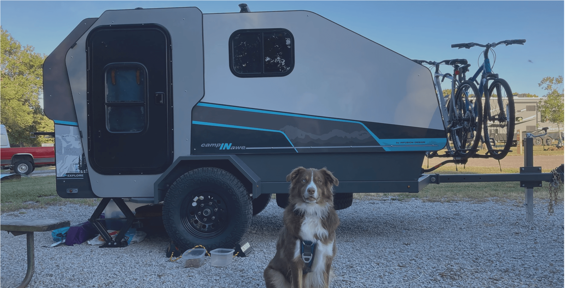 campinawe camping trailer parked at a campsite with dog