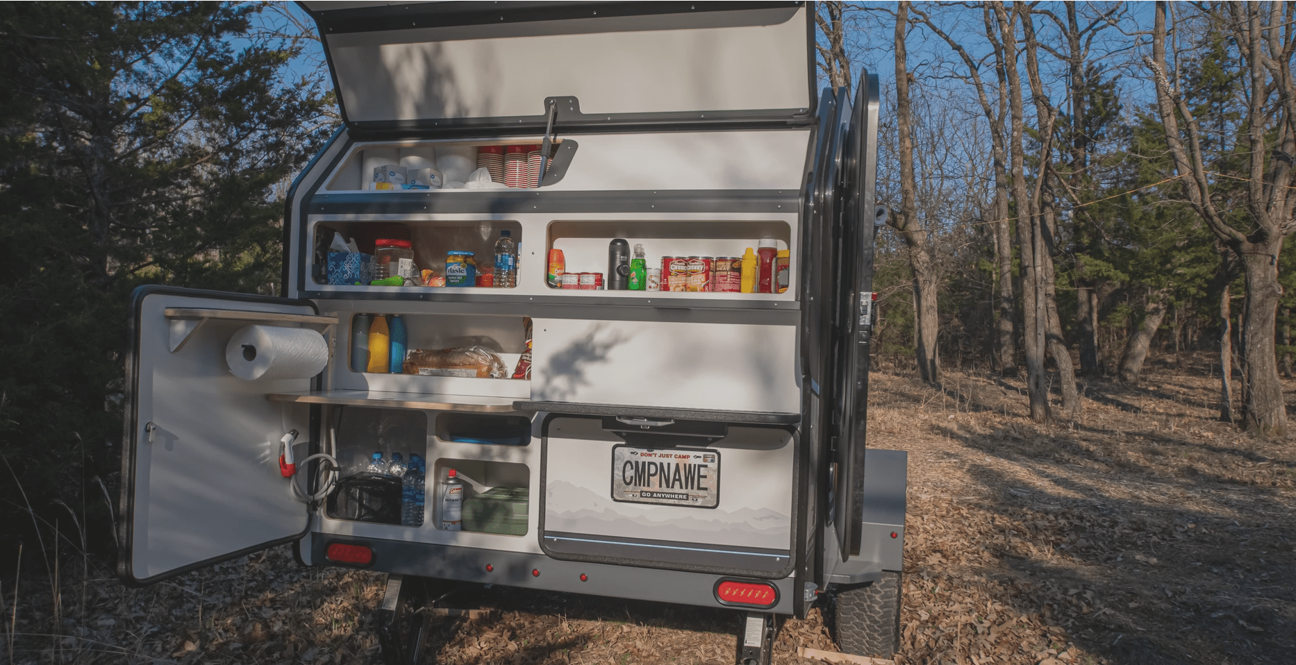 campinawe campine trailer back end with storage cubbies and a rollout cook stove