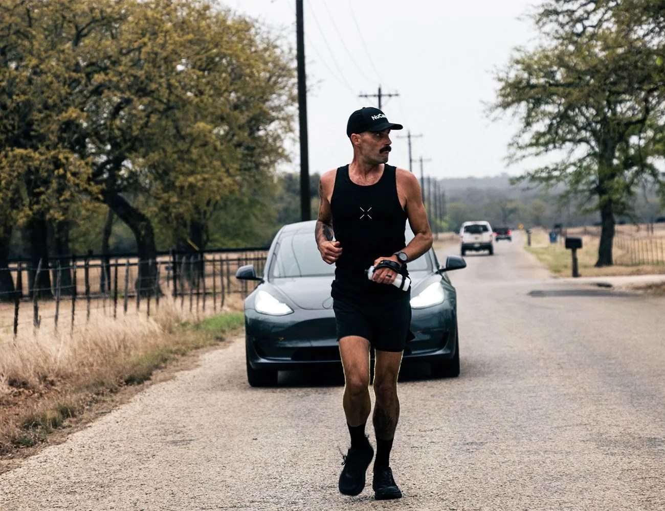 runner racing against a tesla